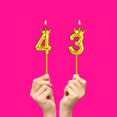 Hands holding number-shaped candles - Birthday number 43