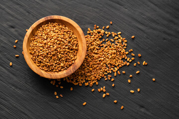 Methi Dana - Dried organic fenugreek seeds in the wooden bowl