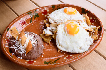 Mexican fried eggs, with chilaquiles and beans