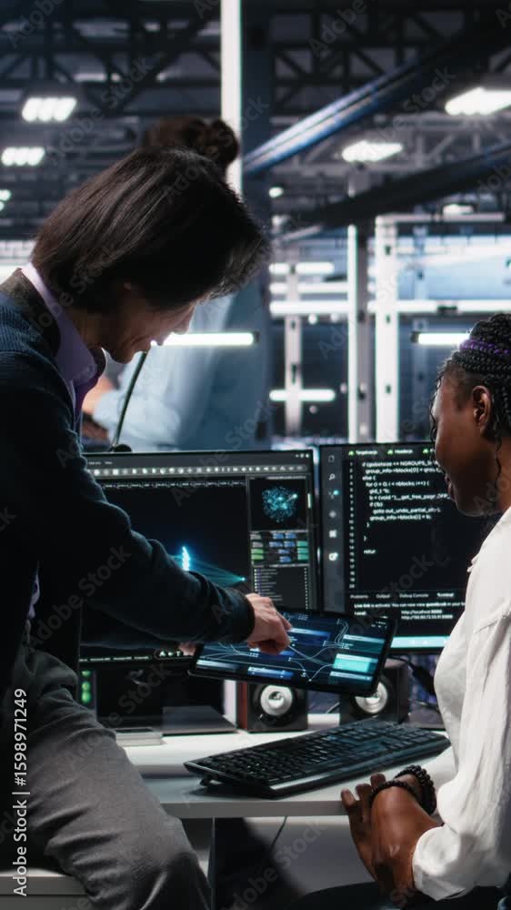 Fototapete vertical video senior engineer and trainee in data center working on neural network software develop
