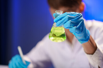 A young male scientist examining a in beaker a lab.