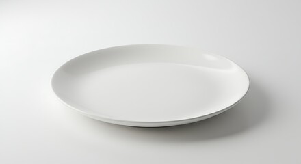 A pristine white plate on a clean white surface, ready for serving any meal or culinary creation.