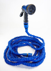 Blue garden hose with spray nozzle on white background