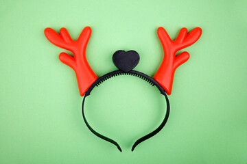 Funny reindeer antlers headband on green background