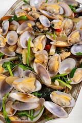 angle view dish of fresh homemade stir-fried clams at vertical composition