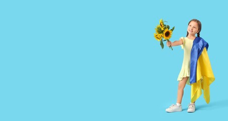 Cute little girl with Ukrainian flag and sunflowers on blue background with space for text