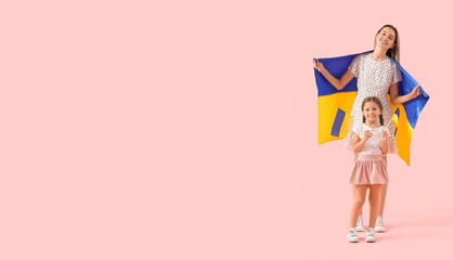 Cute little girl and her mother with Ukrainian flags on pink background with space for text