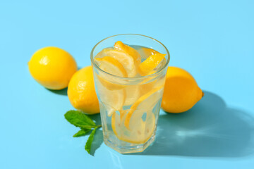 Glass of tasty lemonade with mint on blue background