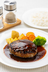 白いテーブルにハンバーグとライスの洋食セット