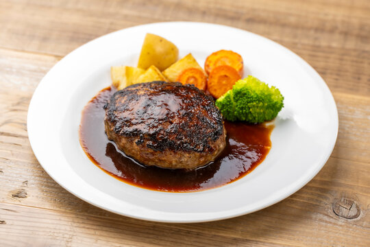ソースがかかったハンバーグと温野菜の洋食プレート