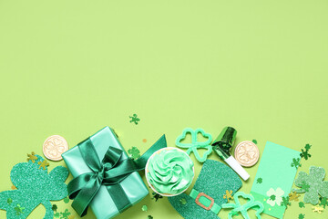 Gift box with cupcake and decor for St. Patrick's Day on green background