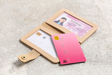 Composition with beige credit holder, cards and driver's license on light grunge background, closeup