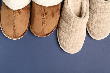 Two pairs of soft slippers on blue background. Top view