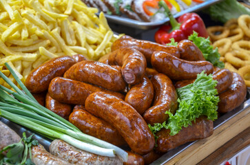 Close-up view of appetizing grilled sausages paired with fries and fresh vegetables arranged in a vibrant display