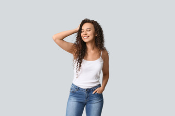 Happy young African-American woman on white background
