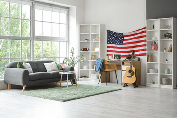 Interior of living room with USA flag, grey sofa and comfortable workspace