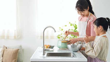 キッチンで料理する親子 © metamorworks