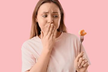 Sick young woman with shrimp on pink background, closeup. Food Allergy Awareness Month