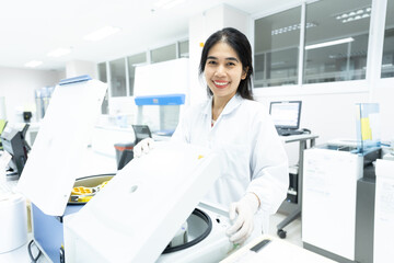 Asian woman scientist and centrifuge for pre analysis blood test  in laboratory...