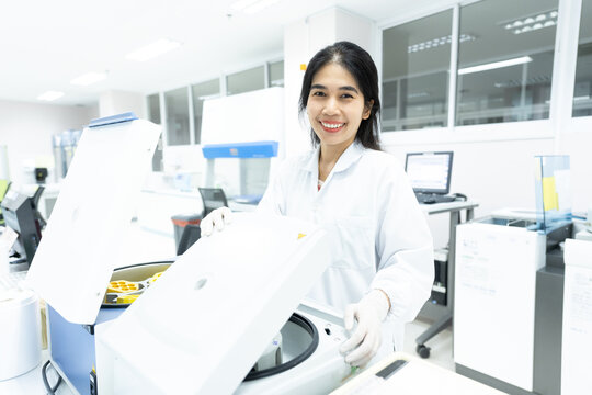 Asian woman scientist and centrifuge for pre analysis blood test  in laboratory department.Laboratory technician using centrifuge device automation machine for testing and diagnostic specimens sample.