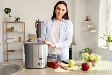 Young woman with modern juicer and apples on table in kitchen