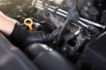 Auto parts. Professional mechanic with torque wrench fixing car indoors, closeup