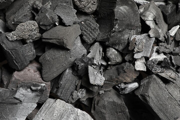 Pieces of black coals as background, top view