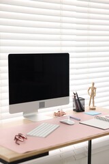 Stylish workplace with wooden desk, stationery and computer at home office