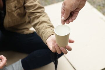 Man giving money to homeless person outdoors, closeup