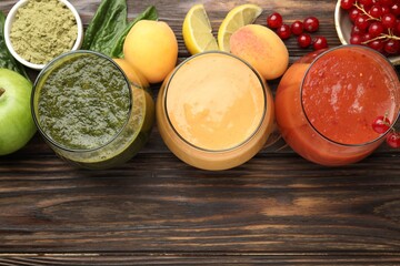 Superfood. Tasty smoothies in glasses and ingredients on wooden table, flat lay. Space for text
