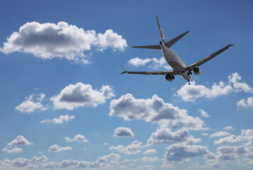 Airplane flying in beautiful blue sky with clouds