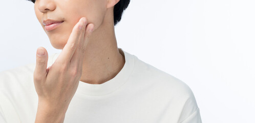 顔に手をあてている若い日本人男性。
