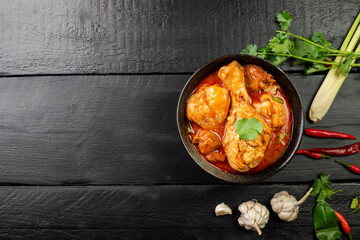 Chicken curry Asian food masala. Traditional cooking healthy food with spices. Arranged on black wooden table background.