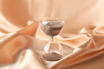 Crystal hourglass on beige background