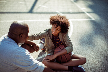 Grandfather and grandson bonding on basketball court outdoors