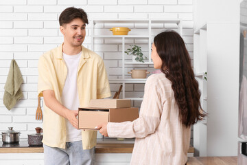 Young couple with parcel box in kitchen