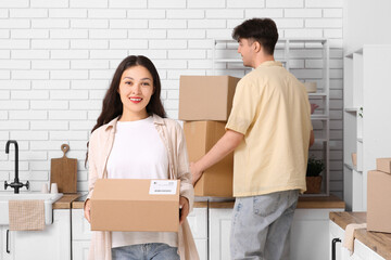 Young couple with parcel boxes in kitchen