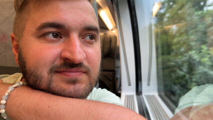 Horizontal travel photo close up. Mature white man with beard, green T-shirt, nautical bracelet on...