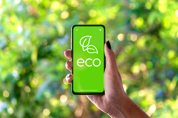 Eco, green, ecological and sustainable concept on mobile phone screen. Woman holding a smartphone in her hand showing an app eco friendly.