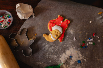 Decorated Christmas cookie shaped like Santa Claus on baking paper
