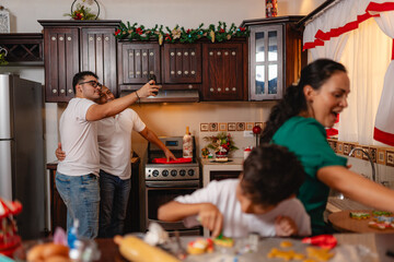 Father and son taking a selfie in a festive kitchen during Christmas baking