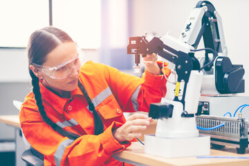 Female engineers checking or maintenance electronic in AI Robot, robot arm in the manufacturing...