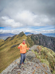 Fototapeta premium Pichincha Province, Quito, Ecuador - July 5, 2025: Tourist at the summit of Pasochoa Volcano, located in the Pasochoa Wildlife Refuge. The extinct volcano is 4,200 meters high.