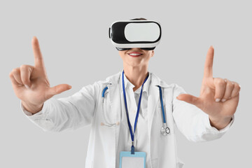 Female doctor in VR glasses using virtual screen on light background