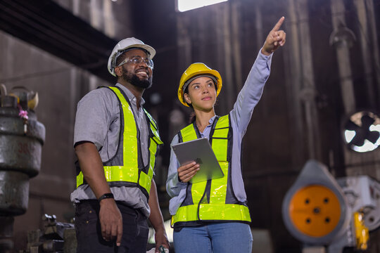 African american engineers male and female in Heavy industry engineers in steel metal manufacturing factory engineering. Train maintenance machine factory.