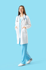Female medical intern walking on blue background