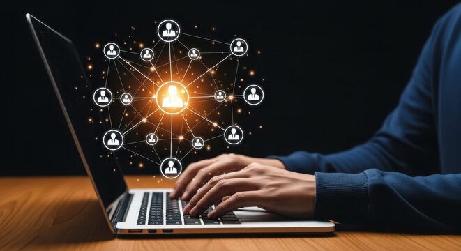 Person types on a laptop showing glowing network connecting people icons against a dark backdrop