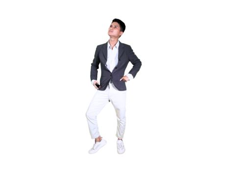 A young man in casual attire is captured mid-air in a squatting pose, looking down at his hands against a white background.