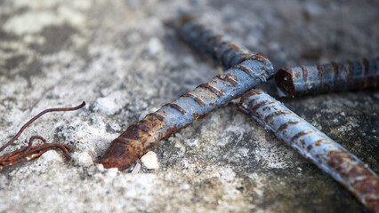 Rusty steel rod on the concrete floor. Close up. Selective focus.