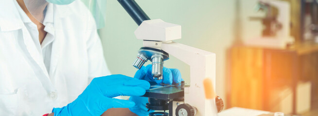 Fototapeta premium Banner Scientist man look Microscope research in science laboratory. Banner Asian scientist use microbiology microscope in laboratory equipment chemistry lab. Biochemistry experiment with copy space
